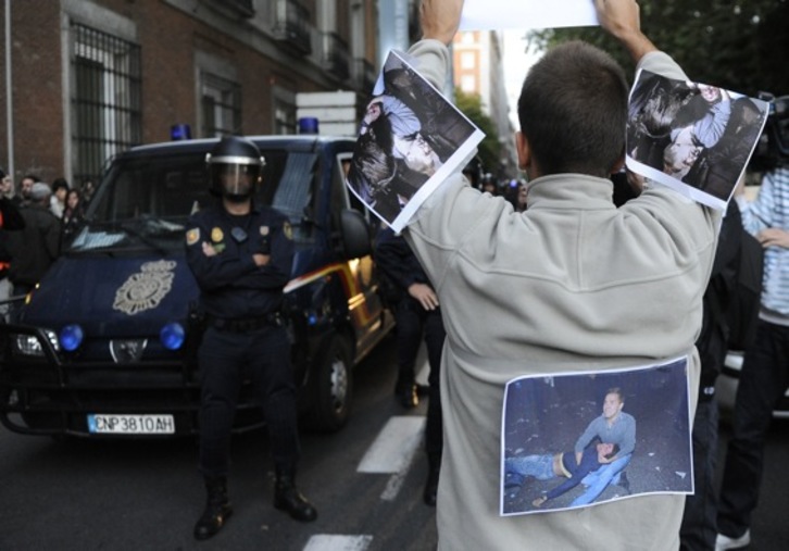 Una persona muestra imágenes de heridos ante un cordón policial. (Dominique FAGET/AFP)