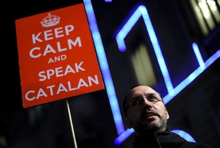Un hombre sostiene un cartel con el lema ‘Keep Calm and Speak Catalan’, el mismo que se ha mostrado durante la sesión del Congreso. (Josep LAGO/AFP)