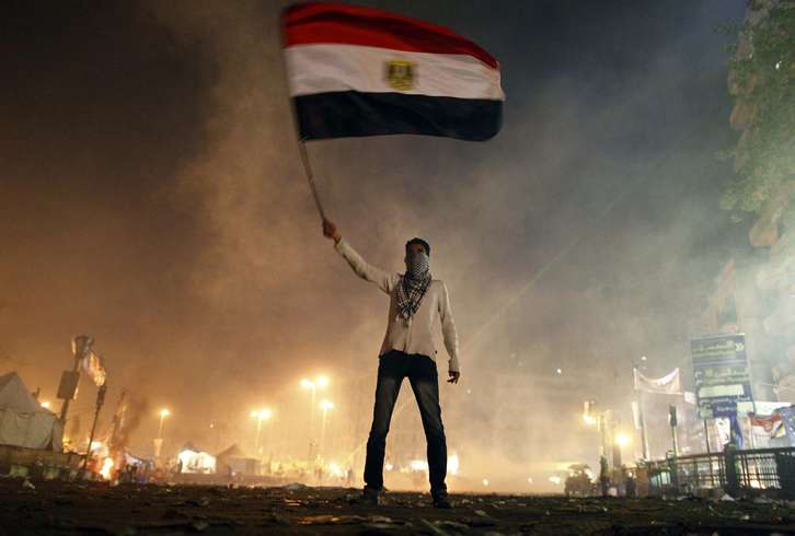Un manifestante ondea la bandera egipcia tras los incidentes en El Cairo. (Mahmoud KHALED / AFP)