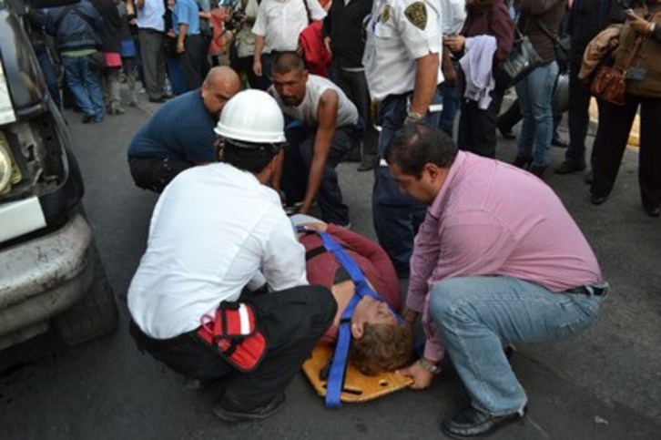 Voluntarios ayudan a los equipos sanitarios con los heridos. (AFP)