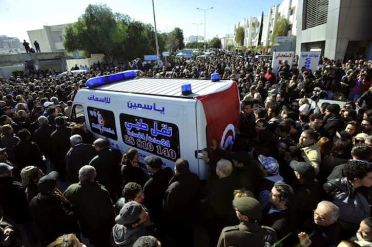 Una multitud rodea la ambulancia que traslada al líder del PPDU muerto a tiros. (Fathi BELAID/AFP PHOTO)