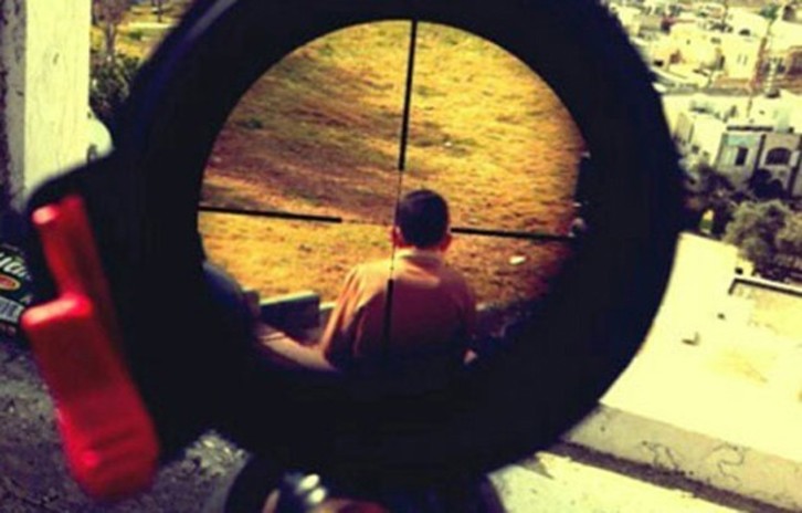 Imagen en la que se ve un niño palestino a través de la mira telescópica de un rifle. 