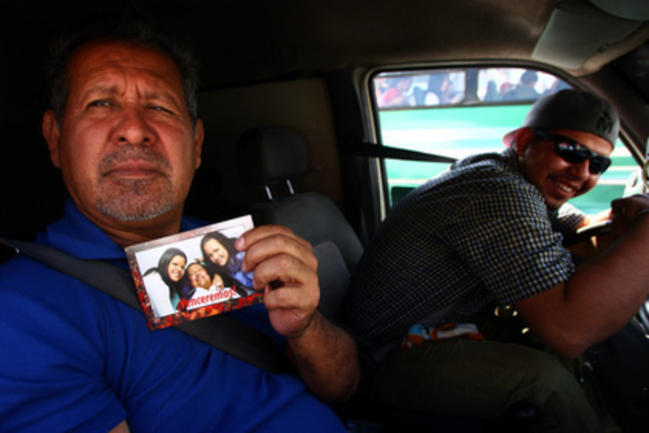 Un hombre muestra la foto de Chávez a su paso por el Hospital Militar de Caracas. (Geraldo CASO/AFP)