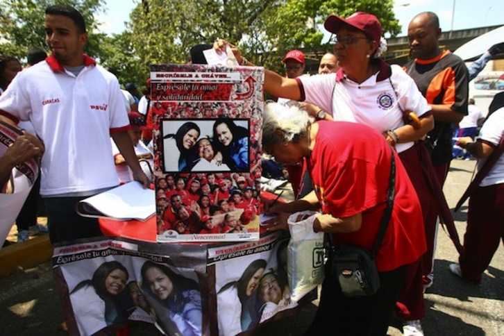 Seguidores de Hugo Chávez escriben cartas de apoyo al mandatario frente al hospital donde permanece ingresado. (Geraldo CASO/AFP PHOTO)