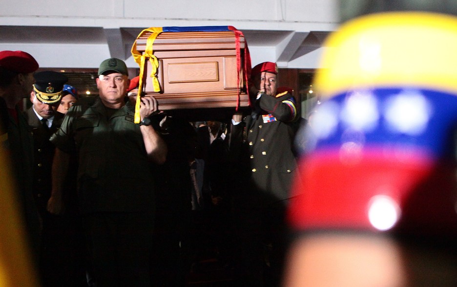 Cargos militares, entre ellos el ministro de Defensa, Diego Molero, portan el ataúd de Chávez al interior de la Academia Militar. (Marcelo GARCÍA/AFP)