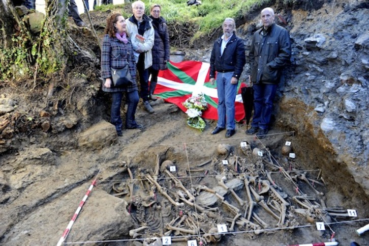 Autoridades y miembros de Aranzadi junto a los restos exhumados. (Juanan RUIZ/ARGAZKI PRESS)