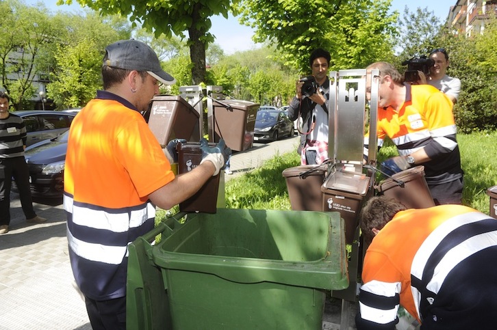 Varios operarios recogen basura orgánica en una calle de Lezo. (Jon URBE/ARGAZKI PRESS)