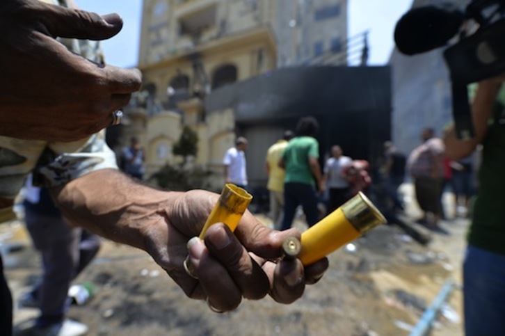 Un hombre muestra cartuchos y casquillos de bala tirados por opositores contra una de las sedes de los Hermanos Musulmanes en El Cairo. (Khaled DESOUKI/AFP PHOTO)  
