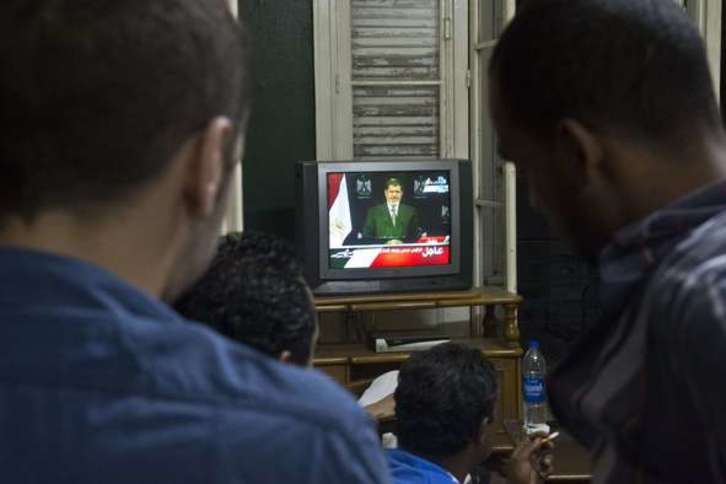 Ciudadanos egipcios siguen el discurso de Morsi a través del televisor. (Khaled DESOUKI/AFP)
