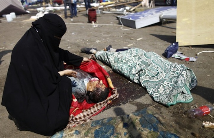 Una mujer observa el cadáver de un manifestante en El Cairo. (Mahmoud KHALED/AFP PHOTO)