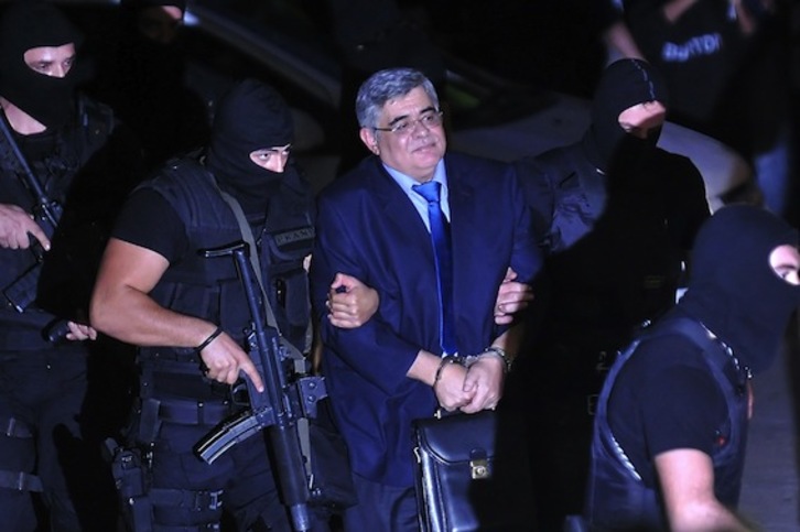 El líder de Amanecer Dorado, Nikolaos Michaloliakos, a su llegada al tribunal, fuertemente escoltado. (Louisa GOULIAMAKI/AFP PHOTO)