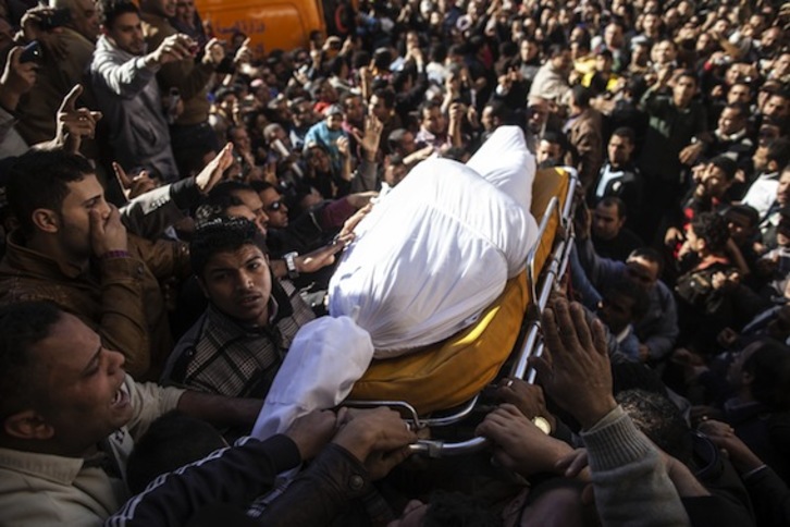 Egipcios portan el cadáver de una de las víctimas del ataque de Mansura. (Mahmoud KHALED/AFP PHOTO)