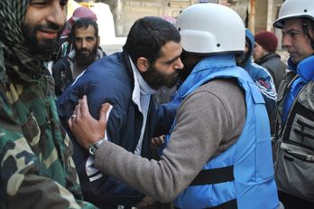 Mimebros de la ONU y la Media Luna Roja son recibidos por soldados opositores en Homs. (Bassel TAWIL /AFP)