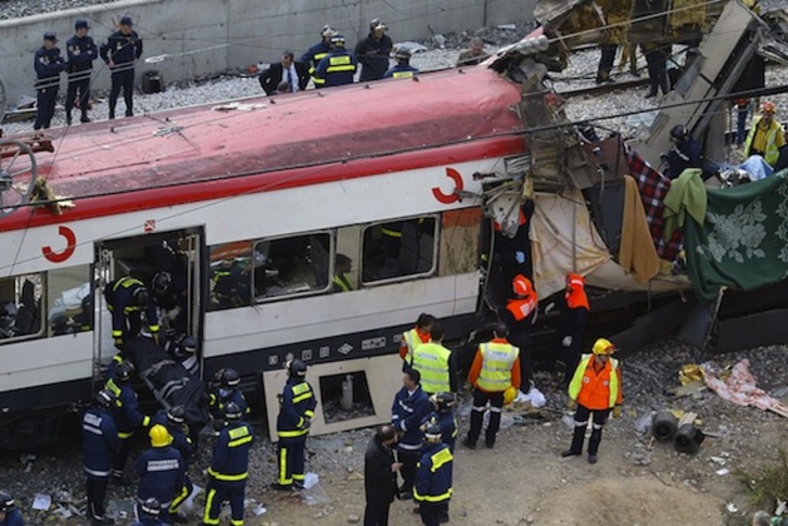 Los servicios de emergencias evacúan cadáveres del tren que explotó mientras llegaba a la estación de Atocha. (Pierre Philippe MARCOU/AFP PHOTO)