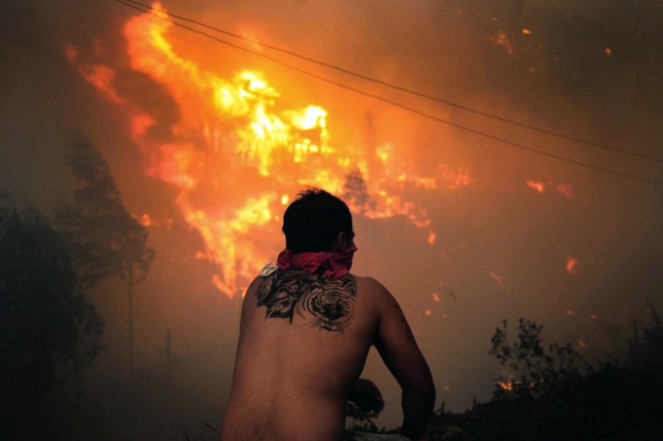Un hombre avista la desoladora imagen que deja el incendio. (Felipe GAMBOA/AFP)