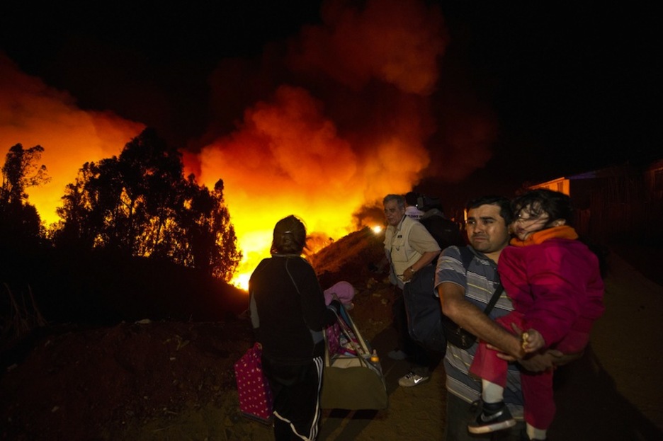 Una familia abandona su hogar por la amenaza de las llamas. (Martin BERNETTI/AFP)