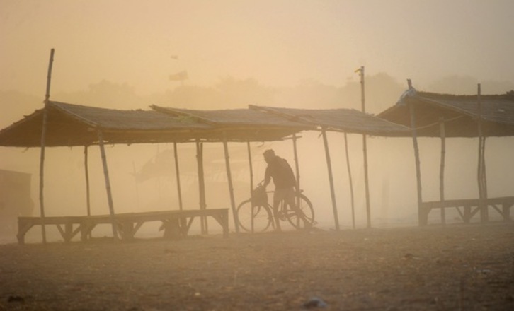 Un hombre circula con su bicicleta durante una tormenta de polvo en India. (Sanjay KANOJIA/AFP PHOTO)