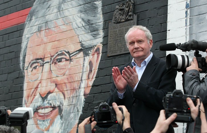 McGuinnes frente a un mural de Adams en el acto organizado por Sinn Fein exigiendo su liberación. (Peter MUHLY / AFP)