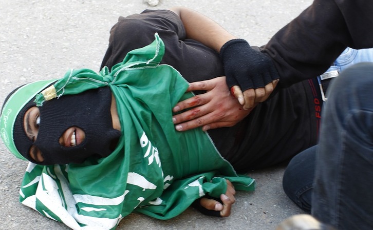 Una persona atiende a uno de los adolescentes palestinos heridos por el Ejército israelí. (Abbas MOMANI/AFP) 
