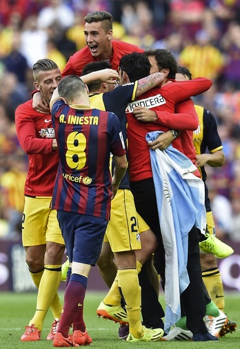 Iniesta se lamenta al final del encuentro mientras el Atlético celebra el triunfo. (Lluis GENE/AFP)