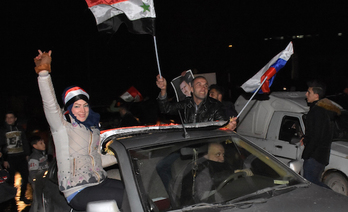 Simpatizantes del Gobierno de Damasco celebran en Alepo que el Ejército ya controla toda la ciudad. (George OURFALIAN / AFP)