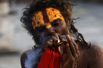 Un sadhu fuma marihuana con una pipa de arcilla tradicional en el templo Pashupatinath en Katmandú.