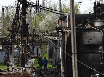 Dos trabajadores observan los daños provocados por los misiles rusos en una subestación eléctrica cerca de la ciudad de Lviv, en el oeste de Ucrania.