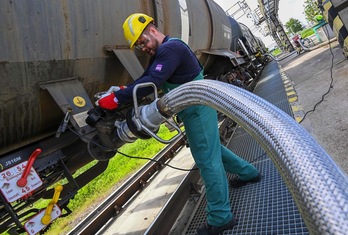 Un trabajador ajusta una manguera de un tren cisterna en la refinería de petróleo Duna, a unos 30 km al sur de Budapest.