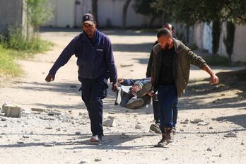 Tres hombres trasladan a un herido en Gaza. 