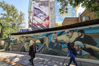 Ciudadanos iraníes pasan ante un mural relativo al ataque a Israel. En farsi, se puede leer «el siguiente golpe será más fuerte». En hebreo, «vuestro próximo error será el último».